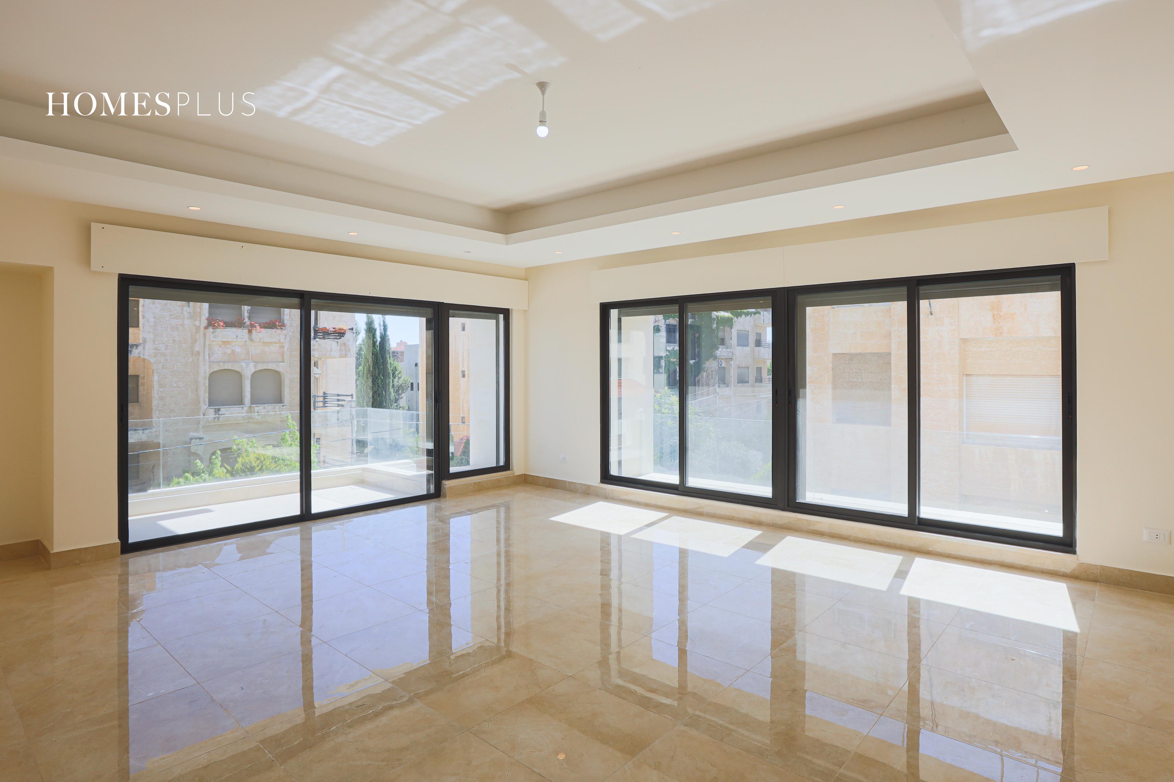 Bright empty living room with large windows, Sweifieh, Amman