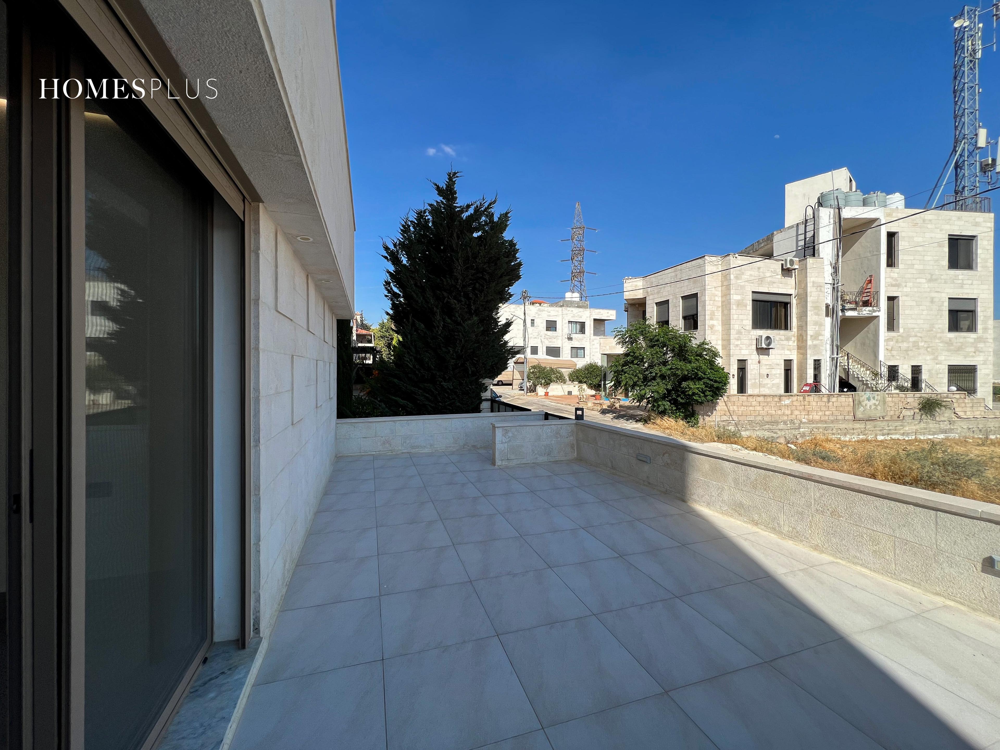 Large tiled terrace with a view of neighbouring buildings, Deir Ghbar, Amman