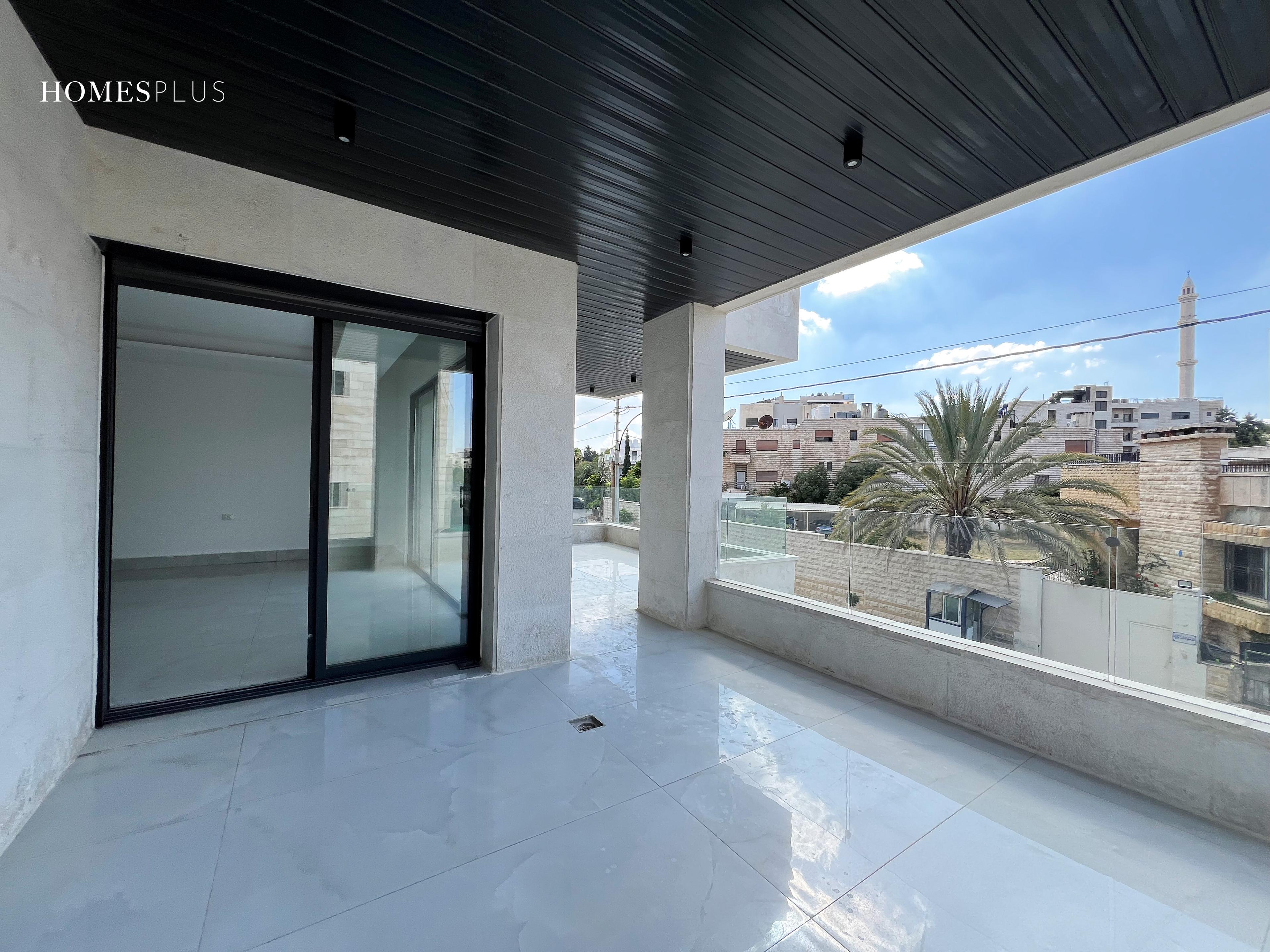 Covered terrace with sliding glass doors and a view, Jabal Amman