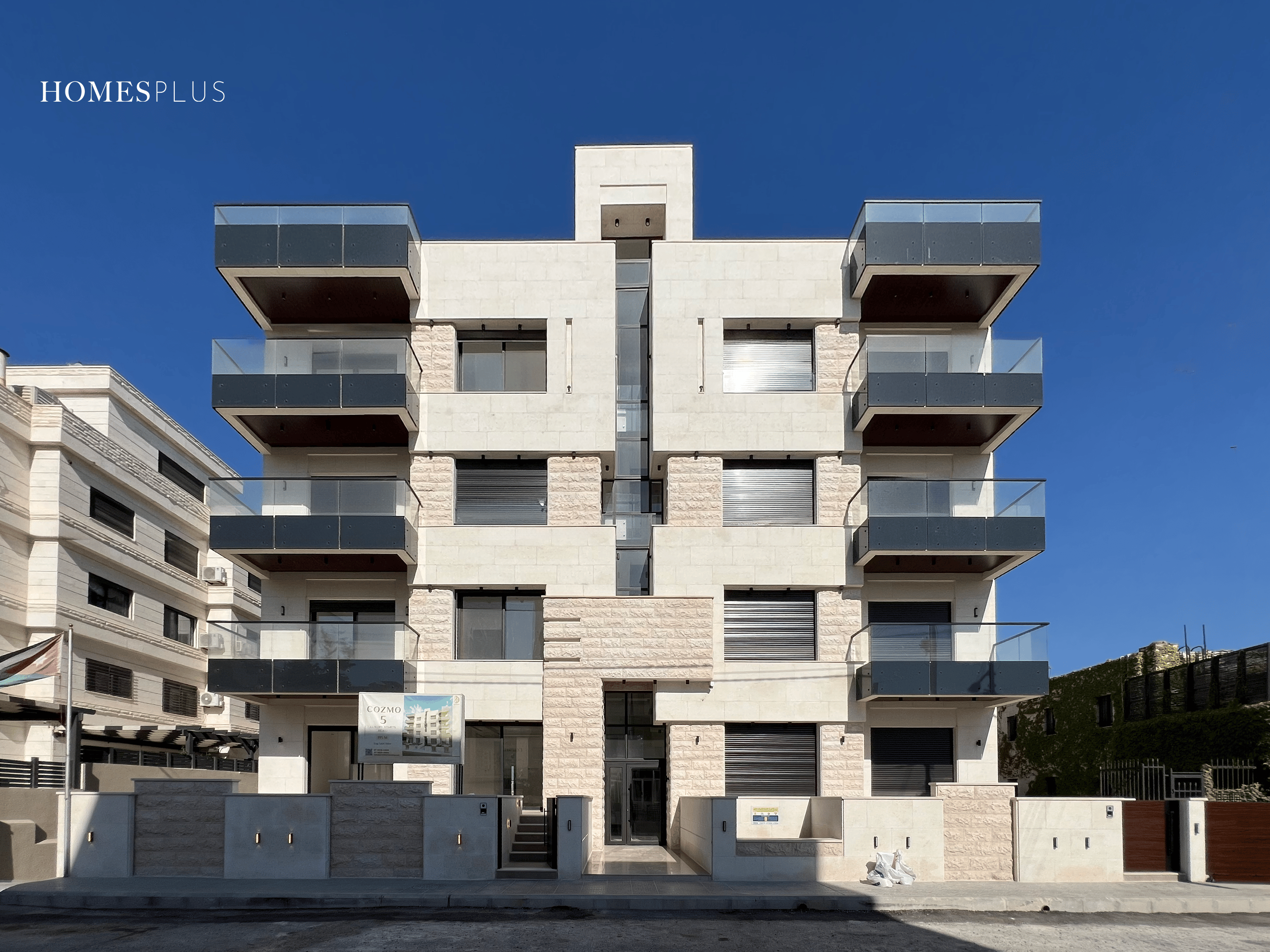 Stone apartment building with dark balconies, Sweifieh, Amman