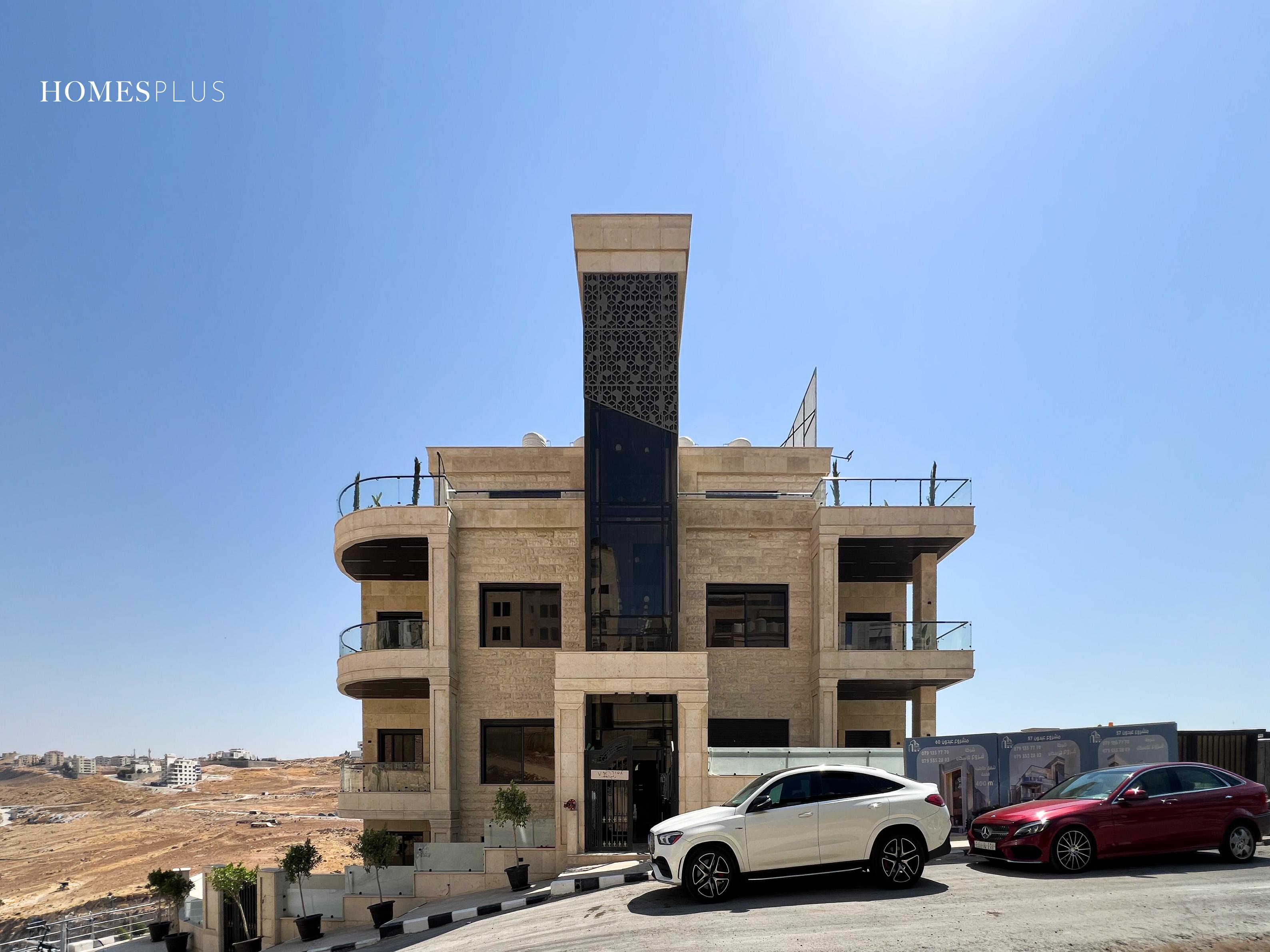 Stone apartment building with a dark central panel, Abdoun, Amman