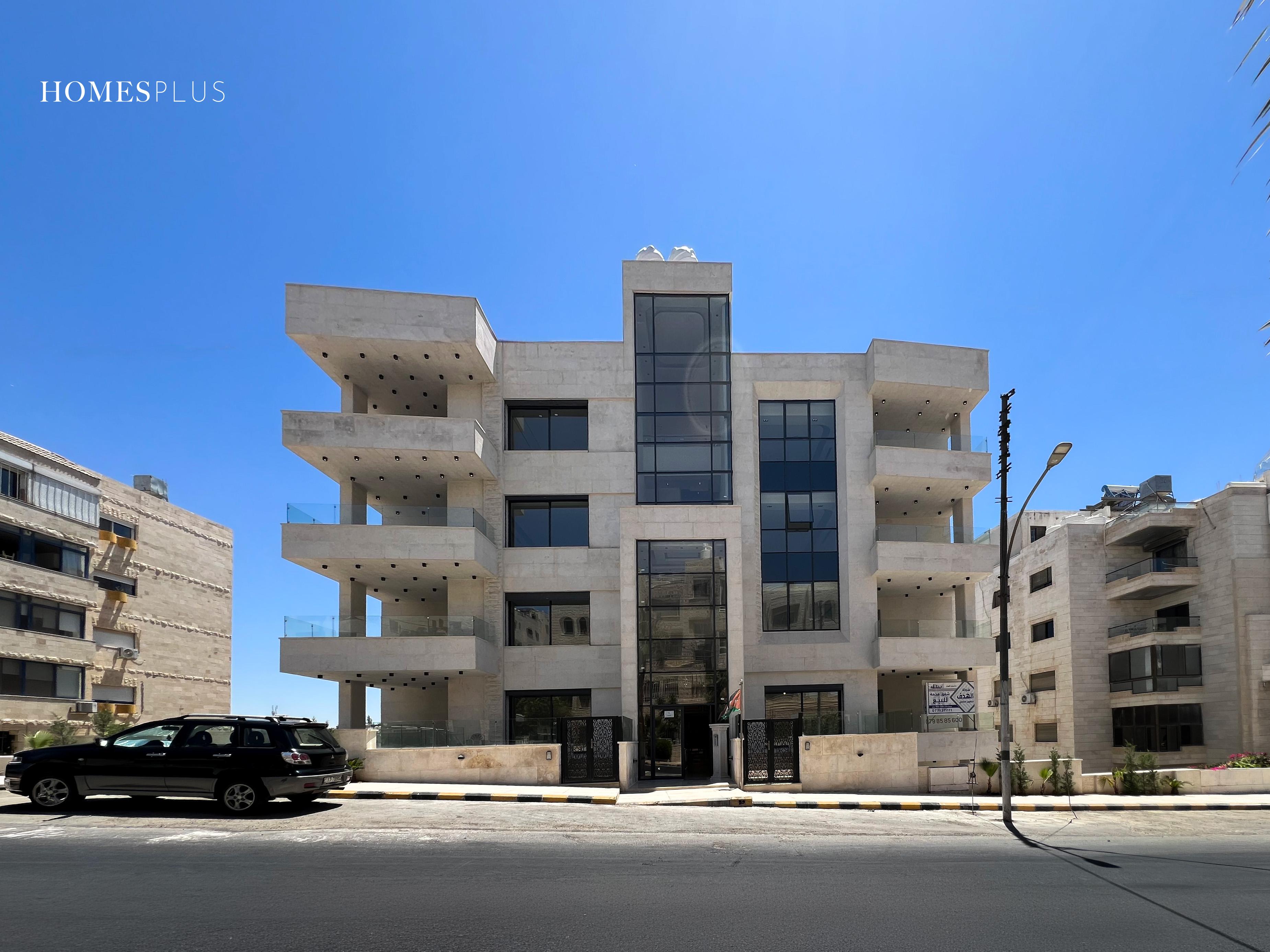 Stone apartment building with wide balconies in Jabal Amman