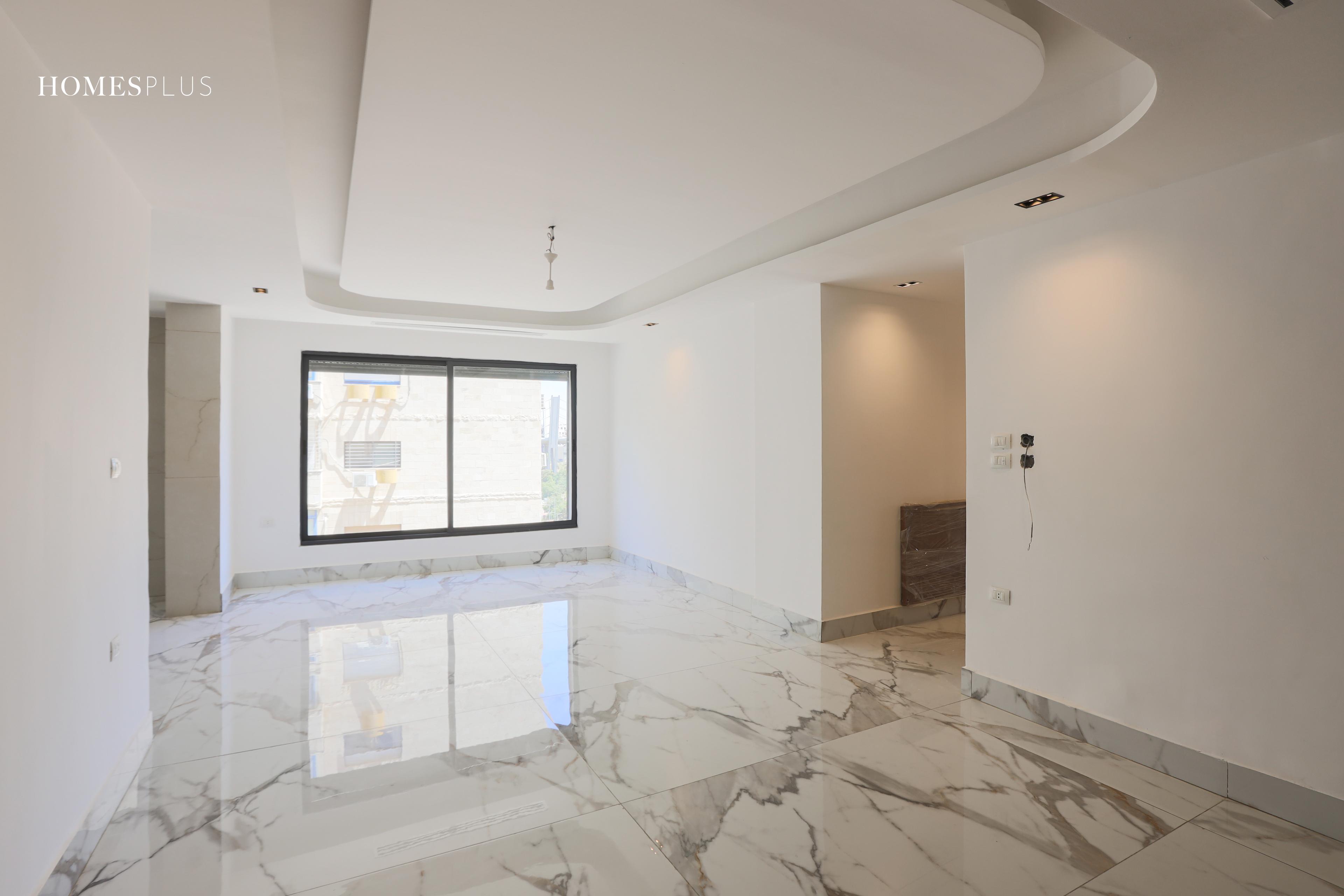 Empty living room with a marble floor in an apartment in Jabal Amman