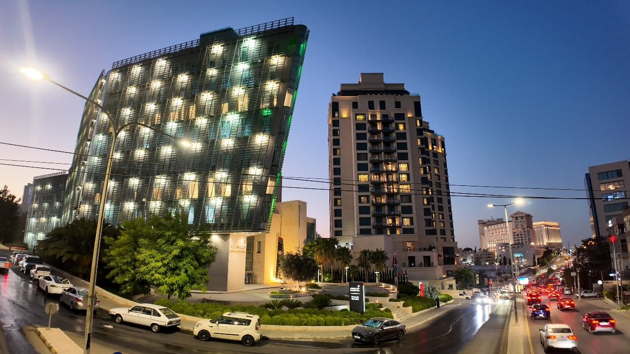 أبراج مضاءة على شارع في عبدون الشمالي، عمّان، مساءً