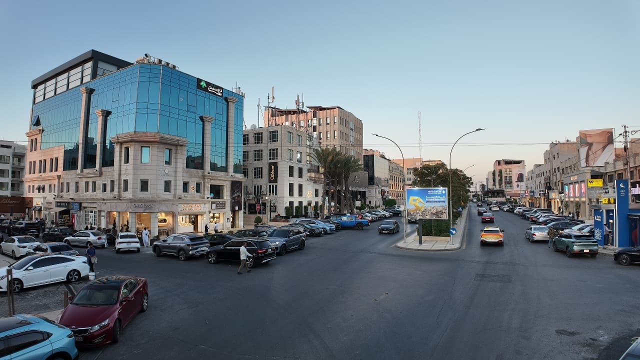 A commercial street in Um Uthaina, Amman, at dusk